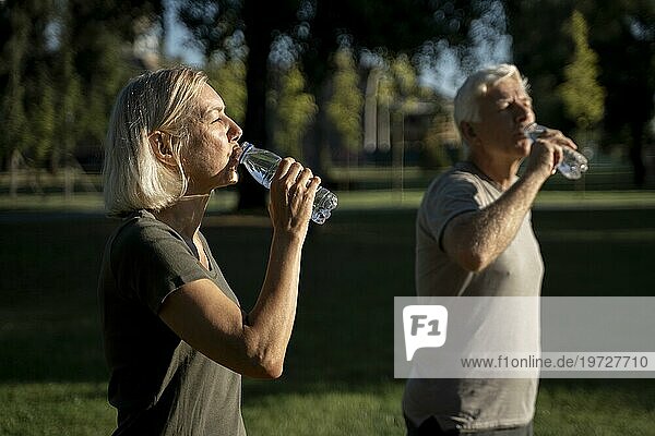 Seitenansicht reifes Paar trinkt Wasser im Freien