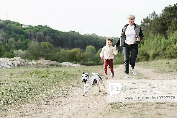 Familie genießt Spaziergang im Park mit Hund
