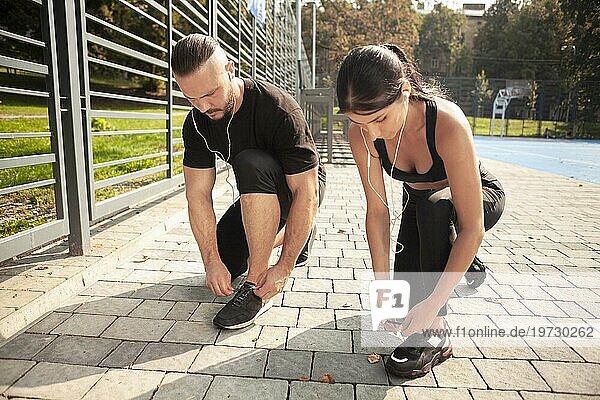 Freunde  die im Freien trainieren  binden ihre Schnürsenkel