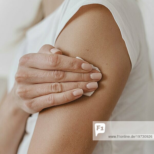 Seitenansicht einer Frau  die ihren Arm hält  nachdem sie geimpft wurde
