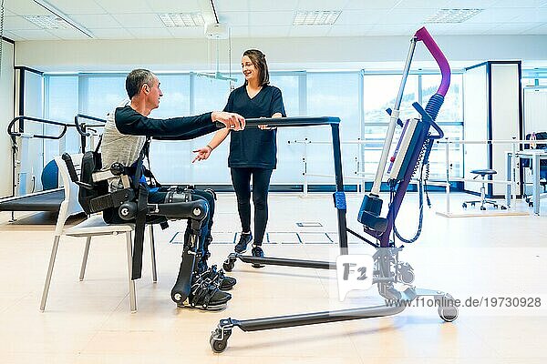 Mechanisches Exoskelett. Physiotherapie Assistentin hebt behinderte Person mit Roboterskelett zum Aufstehen. Futuristische Rehabilitation  Physiotherapie in einem modernen Krankenhaus