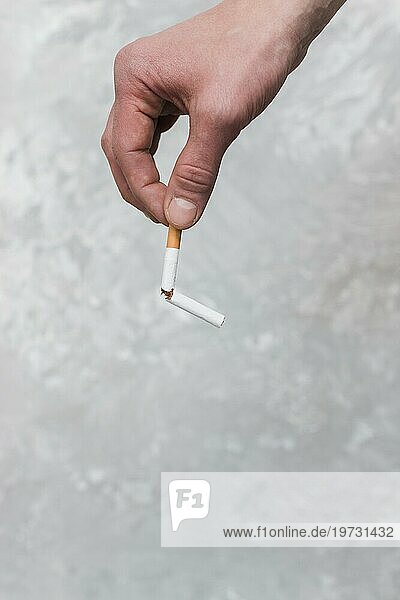 Personen Hand hält gebrochene Zigarette alte Wand Hintergrund