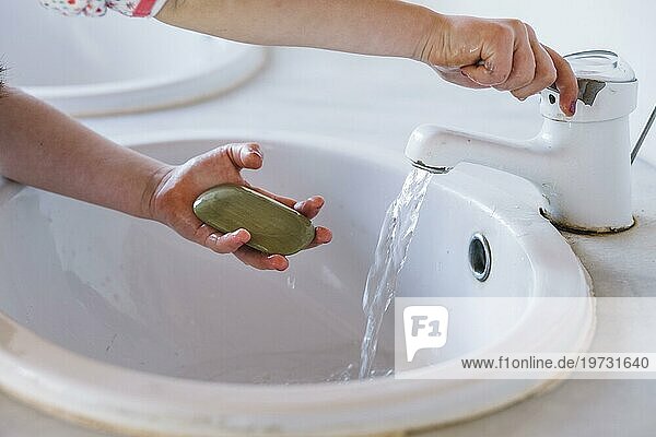Mädchen hält Seife beim Händewaschen am Waschbecken