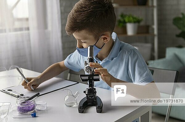 Mittlere Aufnahme Kind lernt mit Mikroskop