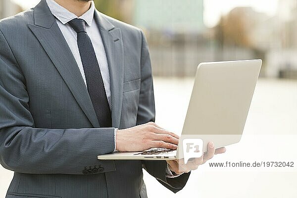 Geschäftsmann benutzt Laptop im Freien