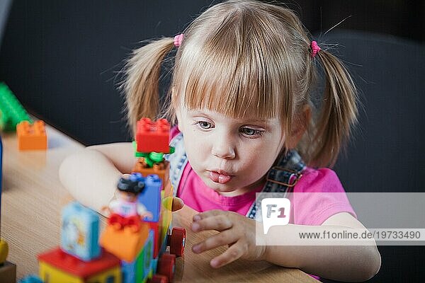 Blondes Mädchen spielt mit Spielzeugeisenbahn