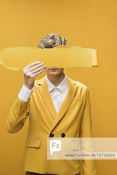 Porträt junger Mann gelbe Szene mit zerrissenem Papier Vordergesicht