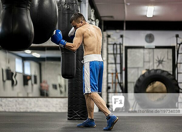 Seitenansicht männlicher Boxer beim Training mit Schutzhandschuhen