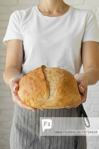 Frau hält frisches rundes Brot
