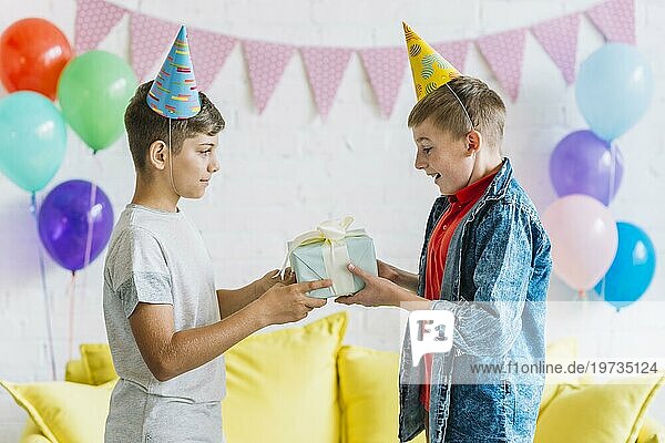 Junge schenkt seinem Freund ein Geburtstagsgeschenk