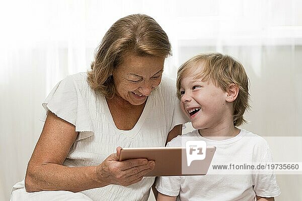 Glückliches Kind Oma mit Tablette