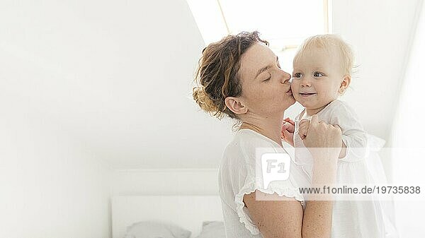 Schöne Mutter küsst Baby Mädchen