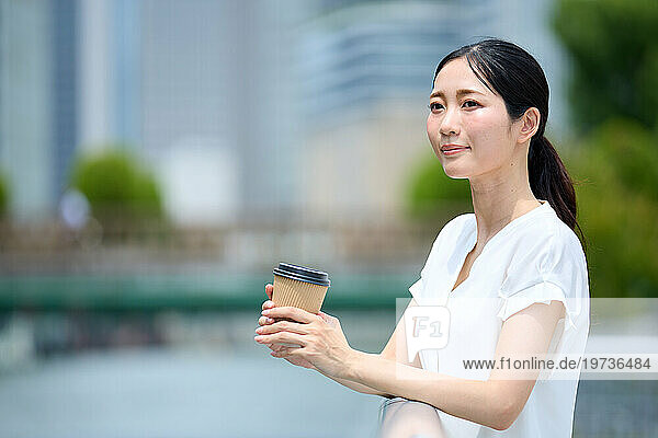 Japanese woman drinking coffee downtown Tokyo