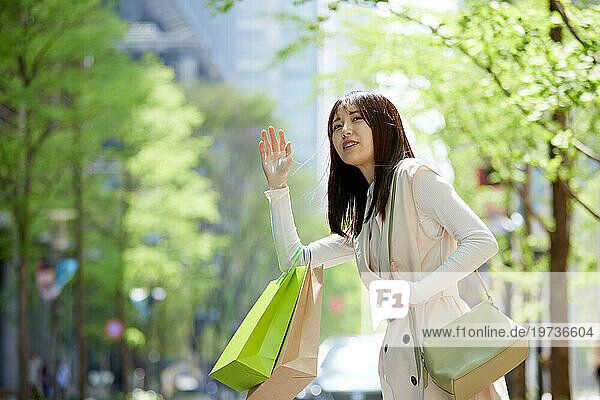 Young Japanese woman calling taxi
