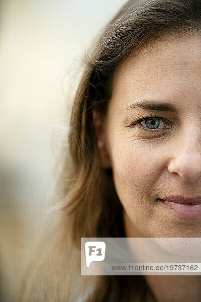 Portrait of half face of adult woman looking at camera