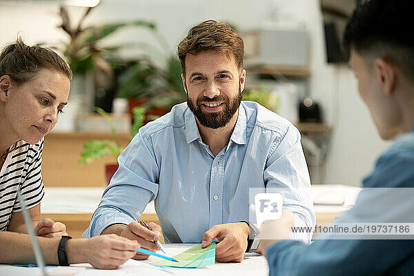 Adult businessman looking at the camera while sitting at table