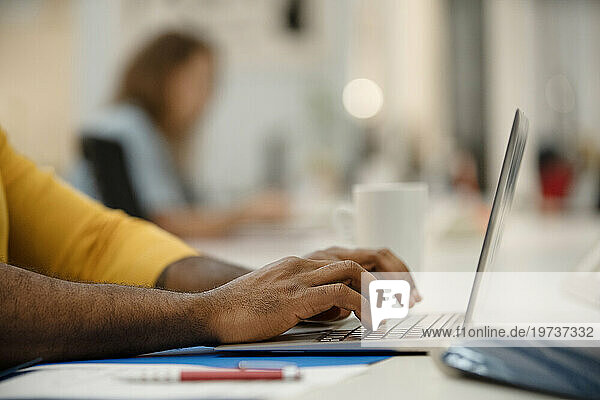 Close-up of African American man's hands using laptop at office