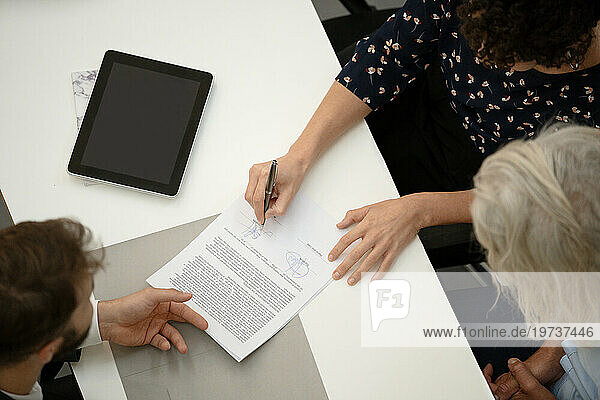 Adult woman signing contract during interview with lawyer
