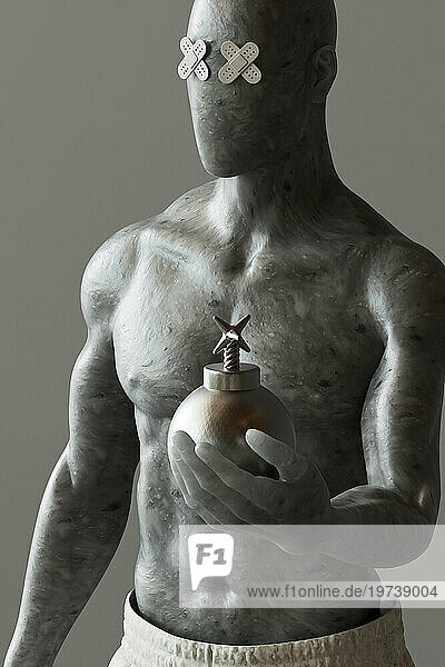 Shirtless mannequin holding artificial bomb against gray background