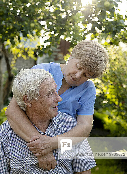 Senior woman embracing man in garden