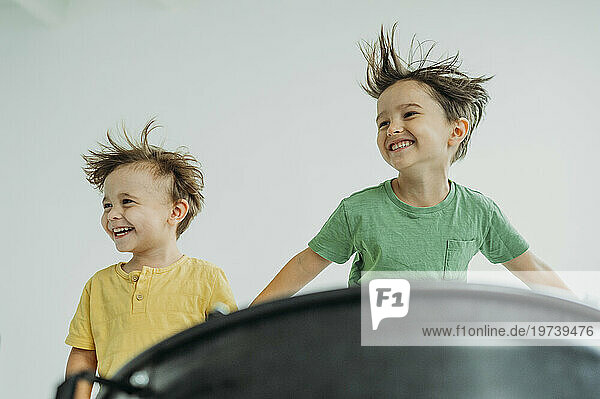 Happy children having fun in front of white wall