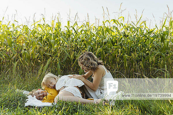 Happy mother enjoying with daughters in front of plants