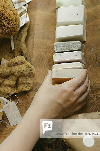 Hand of owner arranging bar of soaps in zero waste store