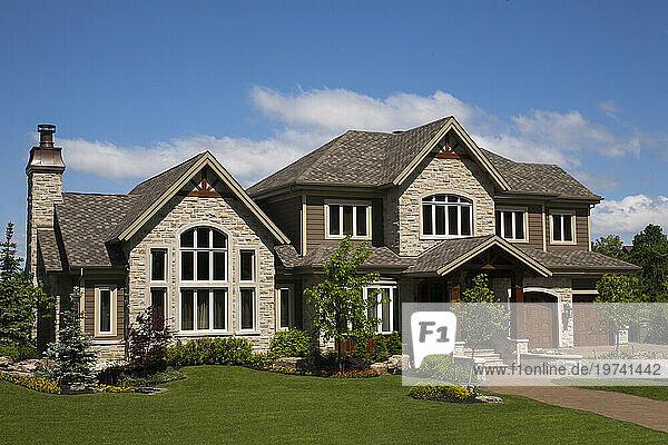 Large single family home with stonework and landscaping