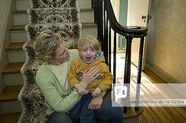 Mother soothing her young son who is crying; Lincoln  Nebraska  United States of America