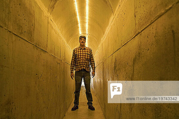 Man stands in a tunnel illuminated with light; Lincoln  Nebraska  United States of America