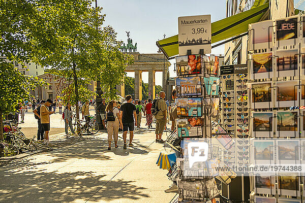 View of Brandenburg Gate  postcards and visitors in Pariser Platz on sunny day  Mitte  Berlin  Germany  Europe
