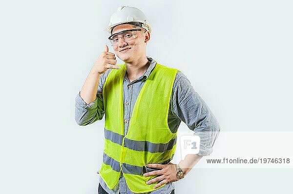 Porträt eines jungen Ingenieurs  der eine Geste macht  isoliert. Hübscher Ingenieur macht Anruf Geste mit den Fingern