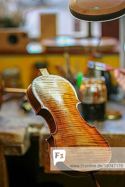 Senior Experte Geigenbauer Geigenbauer Lack mit Pinsel klassische handgefertigte Geige Farbe natürliche Zutaten Rezept in Cremona Italien Heimat der besten Handwerker dieser Art  selektiver Fokus  Bokeh