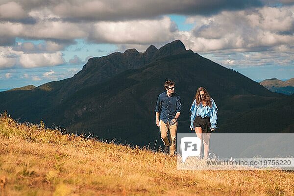 Horizontales Foto mit Kopierbereich eines jungen stilvollen Paares  das den Berg entlang spaziert