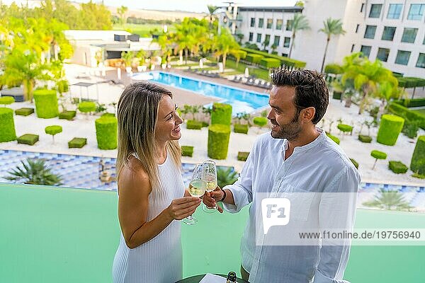 Ein frisch verheiratetes Paar stößt mit Champagner auf der Terrasse eines Luxushotels an