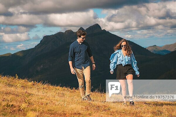 Horizontales Foto mit Kopierbereich eines stilvollen lässigen Paares  das abgelenkt in den Bergen spazieren geht