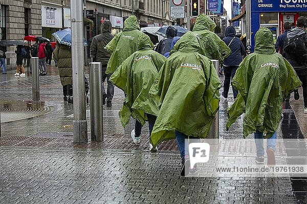 Touristen überqueren die Straße im Stadtzentrum von Dublin an einem sehr regnerischen Tag in der Hauptstadt. Dublin  Irland  Europa