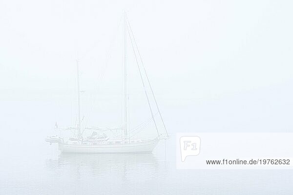 Segelboot  Segelschiff  Yacht mit gesenkten Segeln vor Anker bei schlechter Sicht durch dicken Nebel  dichten Dunst