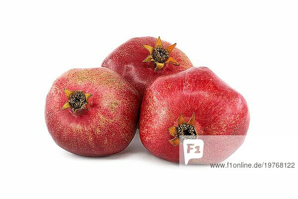 Drei ganze Granatapfelfrüchte vor weißem Hintergrund