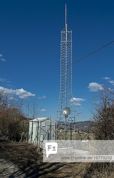 Mobilfunk Antennenturm in ländlicher Umgebung gegen blaün Himmel. Sendemast in der Natur