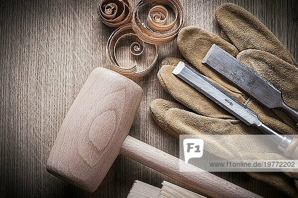 Holzziegel Hammer eingerollt Planung Chips fester Meißel Lederhandschuhe auf Holzbrett Baukonzept