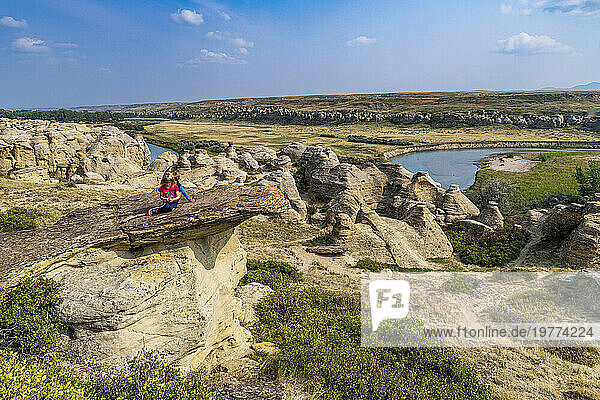Children playing on a Hoodoo along the Milk River  Writing-on-Stone Provincial Park  UNESCO World Heritage Site  Alberta  Canada  North America