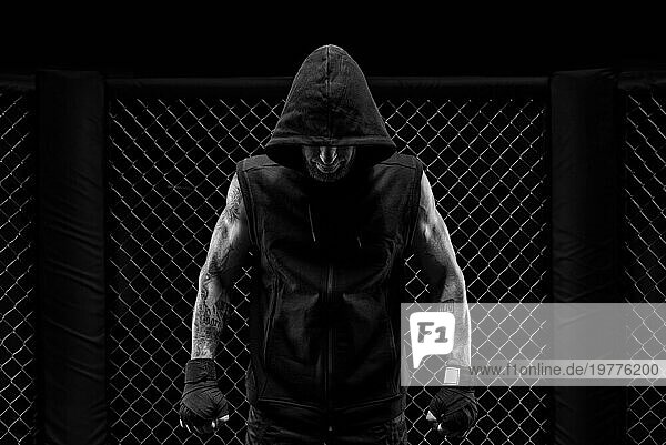 Das dramatische Schwarzweißbild des MMA Kämpfers. Fotografie in einem echten Achteck. Brutaler Kämpfer. Gemischte Medien