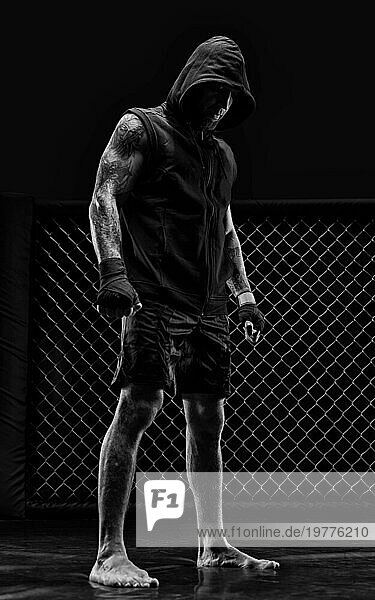 Das dramatische Schwarzweißbild des MMA Kämpfers. Fotografie in einem echten Achteck. Brutaler Kämpfer. Gemischte Medien