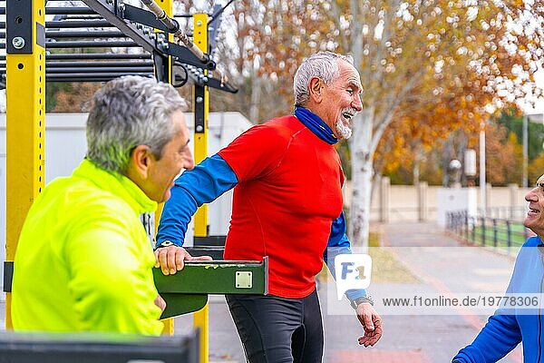 Gruppe reifer Männer im Ruhestand auf einem Sportplatz im Freien  die sich entspannt unterhalten