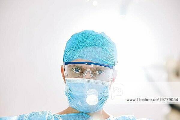 Chirurgischer Arzt im Operationssaal mit Blick in die Kamera