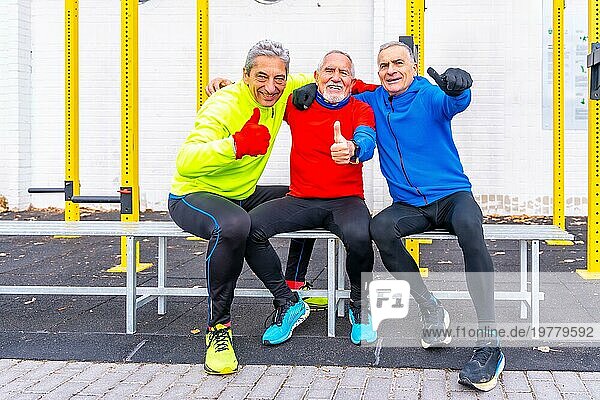 Ältere Männer gestikulieren  dass es ihnen gut geht  nachdem sie auf einem Sportplatz im Freien trainiert haben