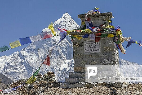 Chorten mit buddhistischen Gebetsfahnen  eine Gedenkstätte am Thokla Pass  die Marisa Eve Girawong  Mitglied der amerikanischen Expedition  gewidmet ist  die während des Erdbebens 2015 im Everest Basislager ums Leben kam. Dies ist eine von vielen Gedenkstätten an diesem Ort  die alle an diejenigen erinnern  die am Everest ihr Leben verloren haben. Im Hintergrund ist die Ama Dablam  der bekannte Bergsteigergipfel  zu sehen. Khumbu  die Everest Region  Himalaya. Der Sagarmatha Nationalpark  das UNESCO Weltnaturerbe. Solukhumbu  Nepal  Asien