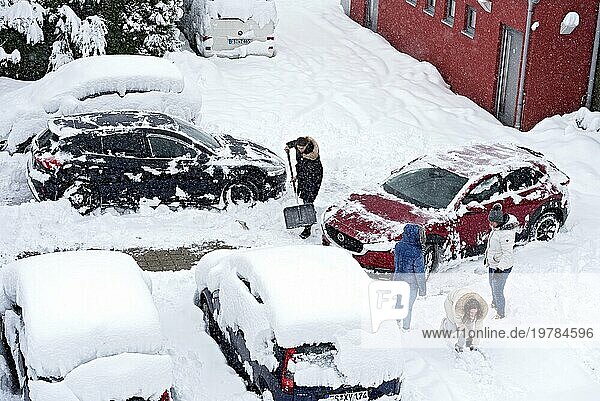 Frauen schaufeln Schnee auf Parkplatz  Auto  PKW  eingeschneit  Neuschnee  starker Schneefall  Schneemassen  Schneechaos  Schneeschaufel  Wintereinbruch  Marzling  Freising  Oberbayern  Bayern  Deutschland  Europa