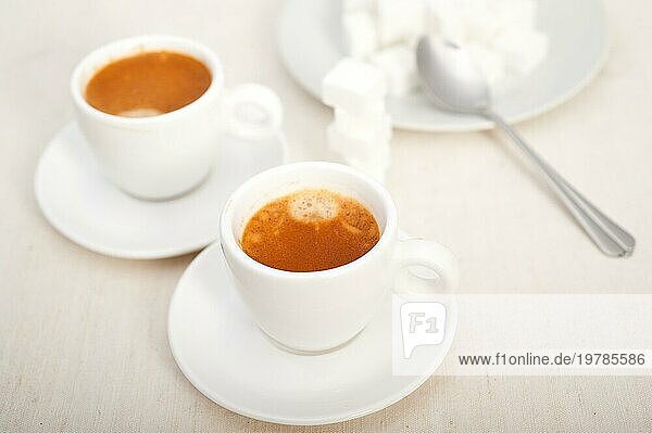 Italienischer Espressokaffee frisch gebrüht Makro Nahaufnahme mit Zuckerwürfeln